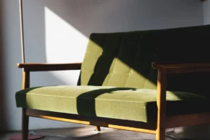 brown wooden framed green padded armchair