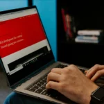 person holding laptop computer inside room