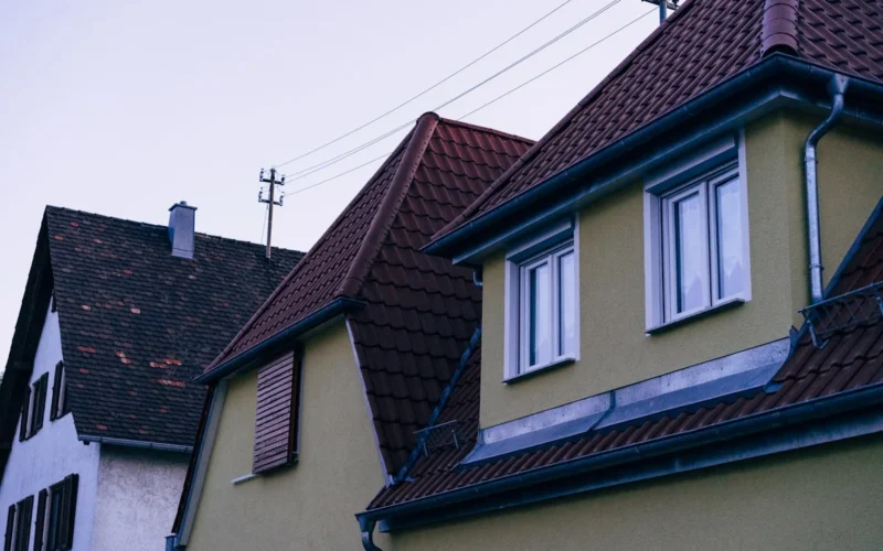 a row of houses with brown roofs and white windows
