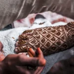 person with foot mendhi tattoo