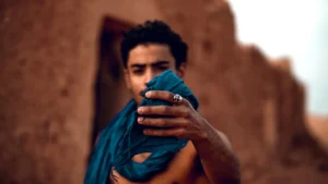 shallow focus photography of man holding blue scarf