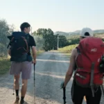 A couple of men walking down a dirt road