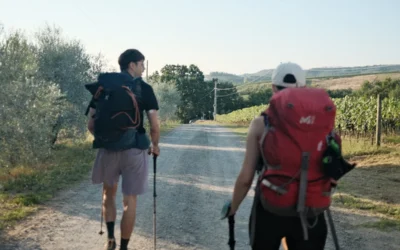 A couple of men walking down a dirt road