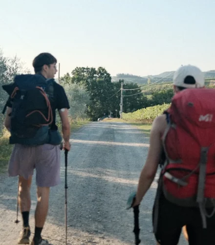 A couple of men walking down a dirt road