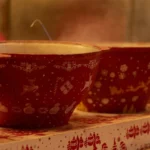 a row of red bowls sitting on top of a shelf