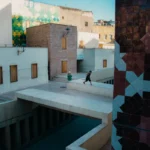 Man runs across a bridge in an urban setting.