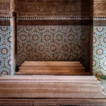 Ornate tiled walls and wooden steps inside building