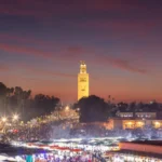 A large crowd of people standing around a city at night
