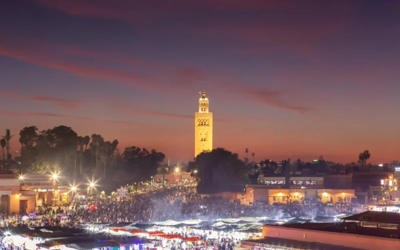 A large crowd of people standing around a city at night