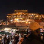 A crowd of people standing around a market at night