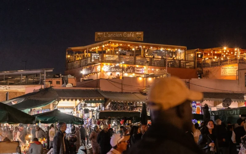 A crowd of people standing around a market at night