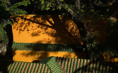 A bench sitting in front of a yellow wall