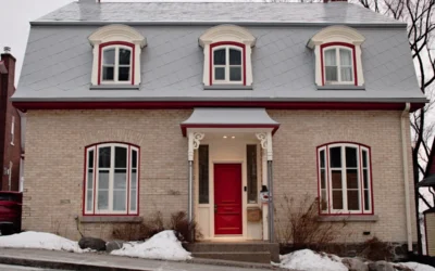 a small brick house with a red door