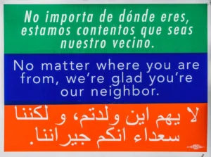 Sign with the message: No matter you are from, we're glad you're our neighbor written in 3 languages.
