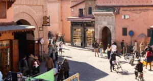A crowd of people walking down a street next to tall buildings