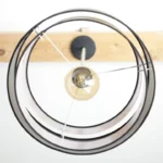 A modern lamp hangs from a wooden beam.