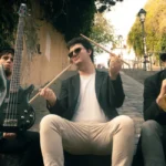 three men playing musical instruments while sitting on ramp beside stairs