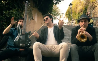 three men playing musical instruments while sitting on ramp beside stairs