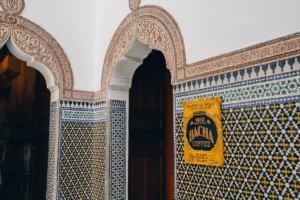 Ornate moroccan tiles with a "bachir coffee" sign.