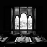 grayscale photo of table setting near window