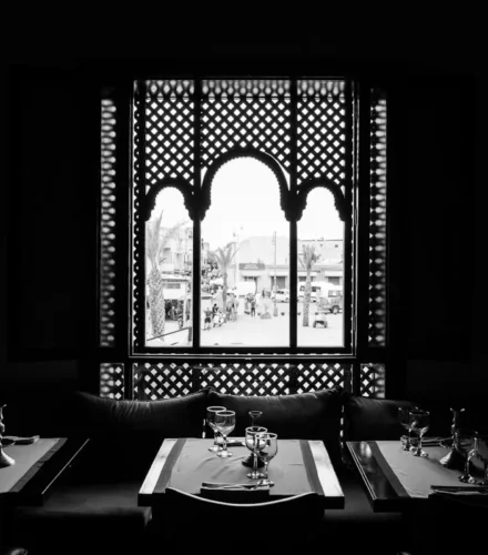 grayscale photo of table setting near window