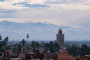 Mosque tower with snow-capped mountains in background.