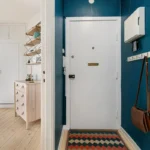 A hallway with blue walls and a white door