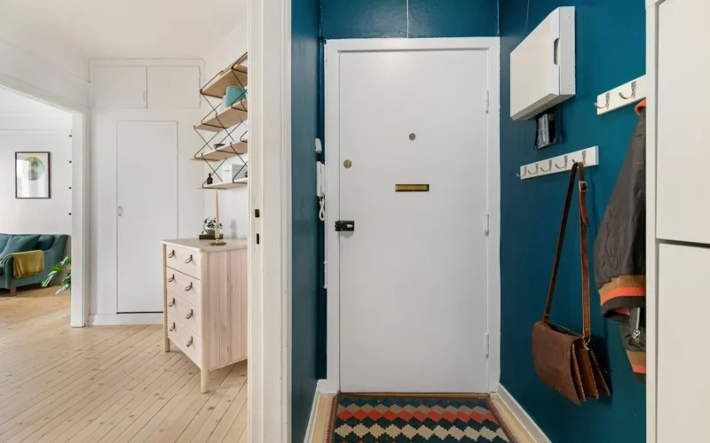 A hallway with blue walls and a white door
