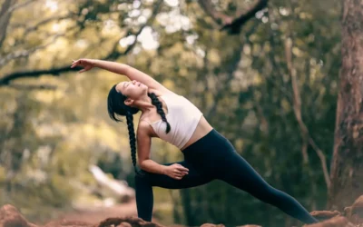 woman in white tank top and black leggings doing yoga during daytime
