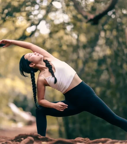 woman in white tank top and black leggings doing yoga during daytime