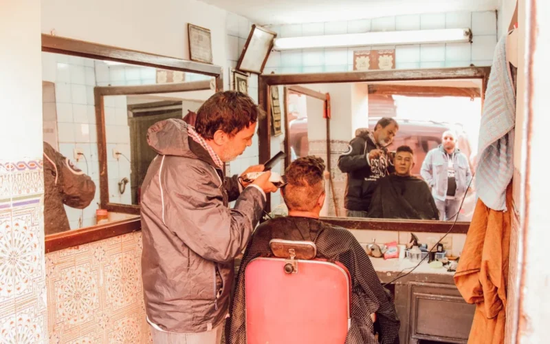 man receiving haircut from man inside shop