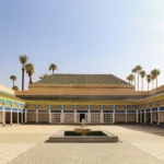 a courtyard with a fountain surrounded by palm trees