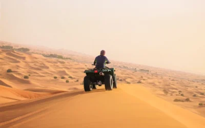 man riding black atv on brown sand during daytime