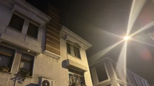 Buildings at night with a bright street light.