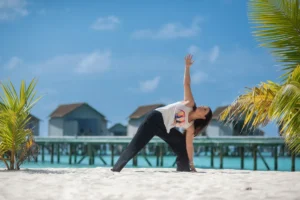 Woman practicing yoga on a tropical beach