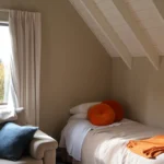 Cozy bedroom with a single bed and window view.
