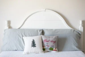 A bed with a white headboard and two pillows