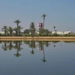 Reflection of some buildings and trees on water in Menara garden